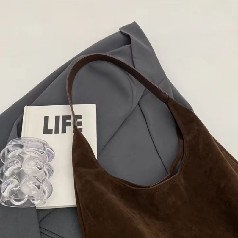 bolsa feminina camurça, bolsa suede feminina, bolsa feminina tipo saco, bolsa feminina de ombro, bolsa feminina grande camurça, bolsa feminina estilo minimalista, bolsa feminina moderna, bolsa feminina elegante, bolsa feminina casual, bolsa feminina macia, bolsa feminina leve, bolsa feminina marrom, bolsa feminina preta